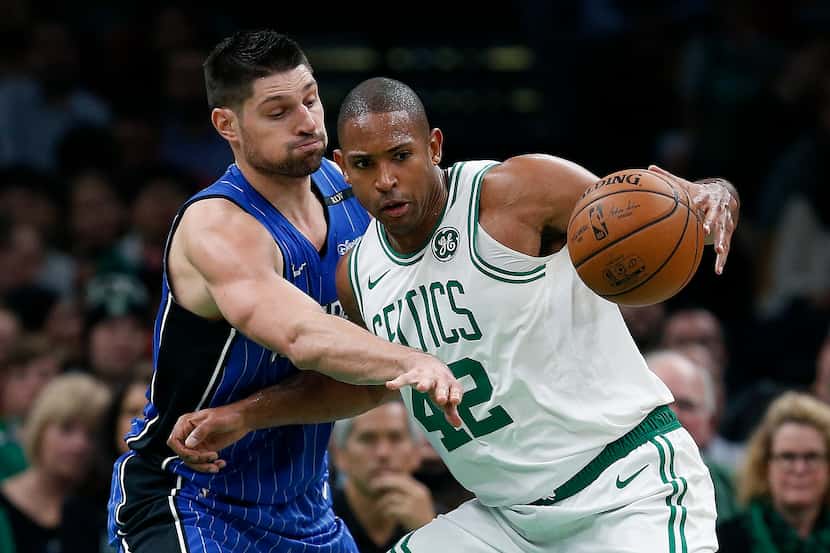 Orlando Magic's Nikola Vucevic, left, defends against Boston Celtics' Al Horford (42) during...