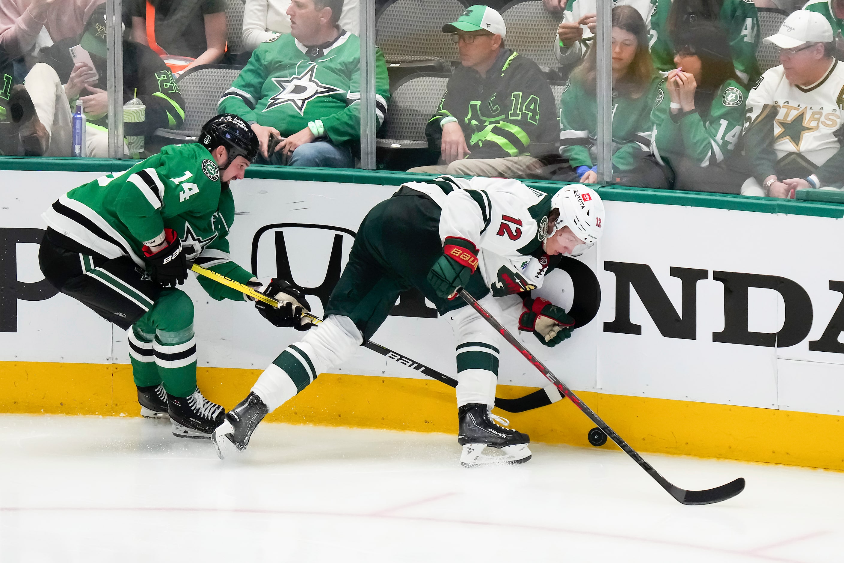 Minnesota Wild left wing Matt Boldy (12) controls the puck along the boards against Dallas...