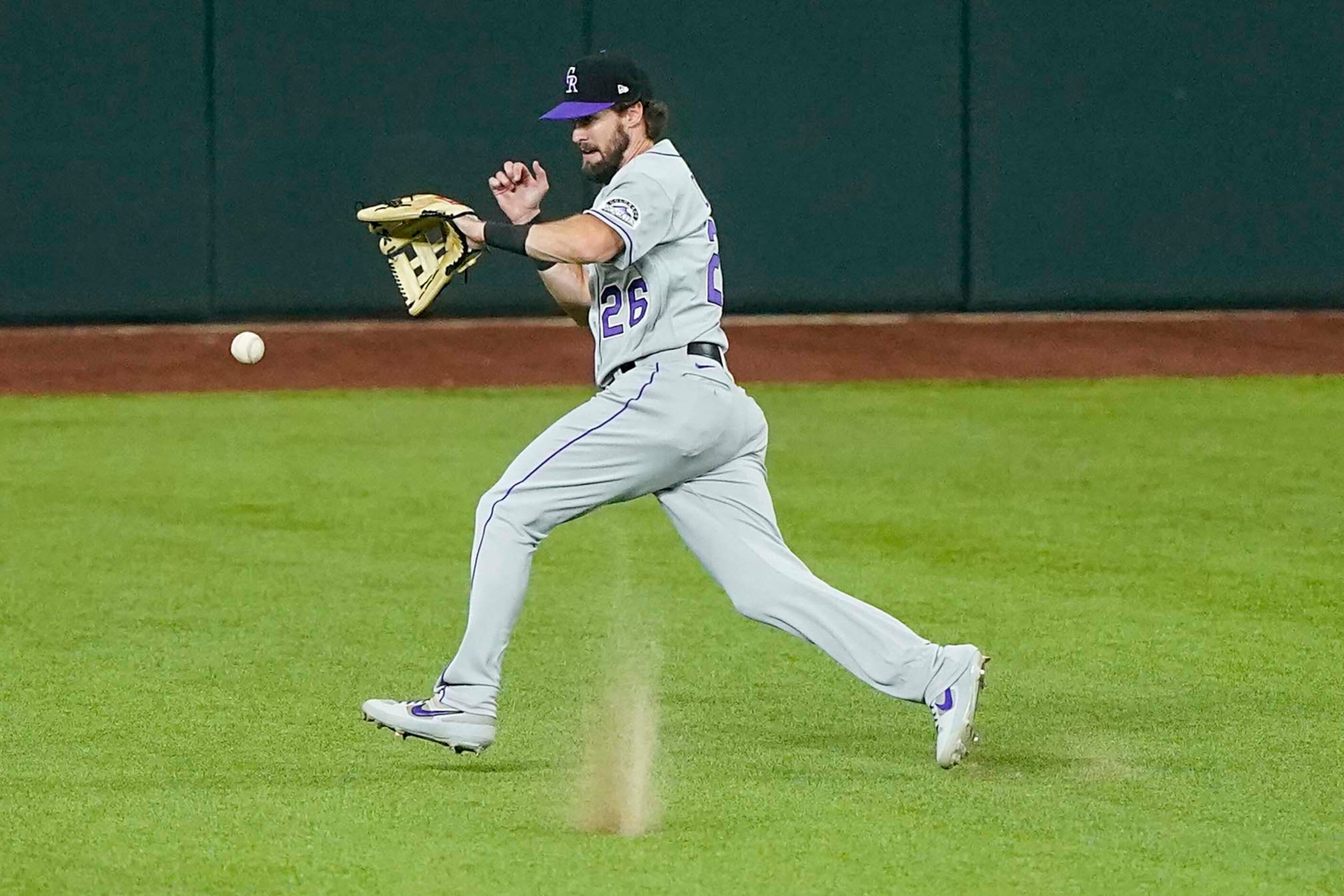 A triple off the bat of Texas Rangers catcher Jeff Mathis gets past Colorado Rockies center...