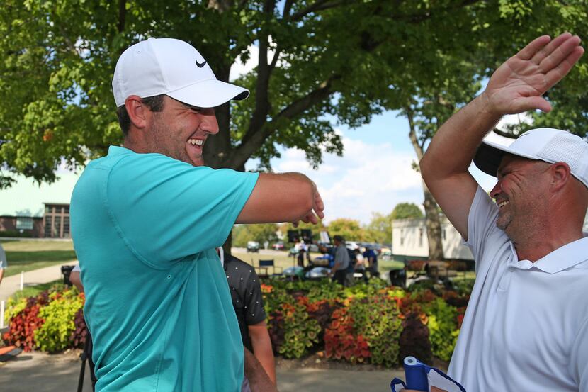 COLUMBUS, OHIO - AUGUST 18: Scottie Scheffler celebrates with his caddie, Scotty McGuinness,...