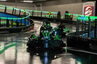 A driver rides a go kart at Andretti Indoor Karting & Games.