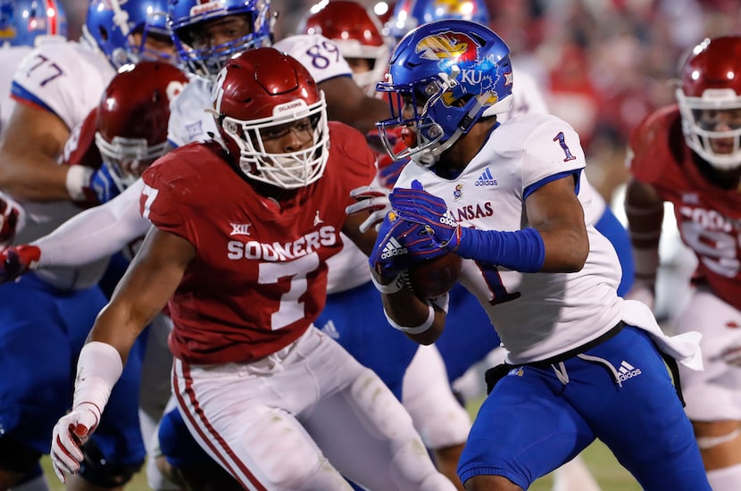 Kansas running back Pooka Williams Jr. (1) runs as Oklahoma defensive end Ronnie Perkins (7)...