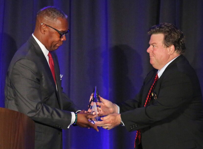 AT&T Chief Compliance Officer David Huntley, left, accepts an ethics award from Michael...