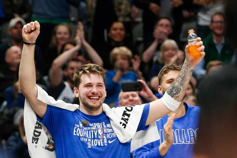 Dallas Mavericks guard Luka Doncic (77) celebrates as center Boban Marjanovic (51) breaks...