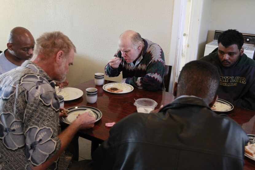 Robert Ceccarelli, center, a former teacher with a master's degree, eats breakfast where he...