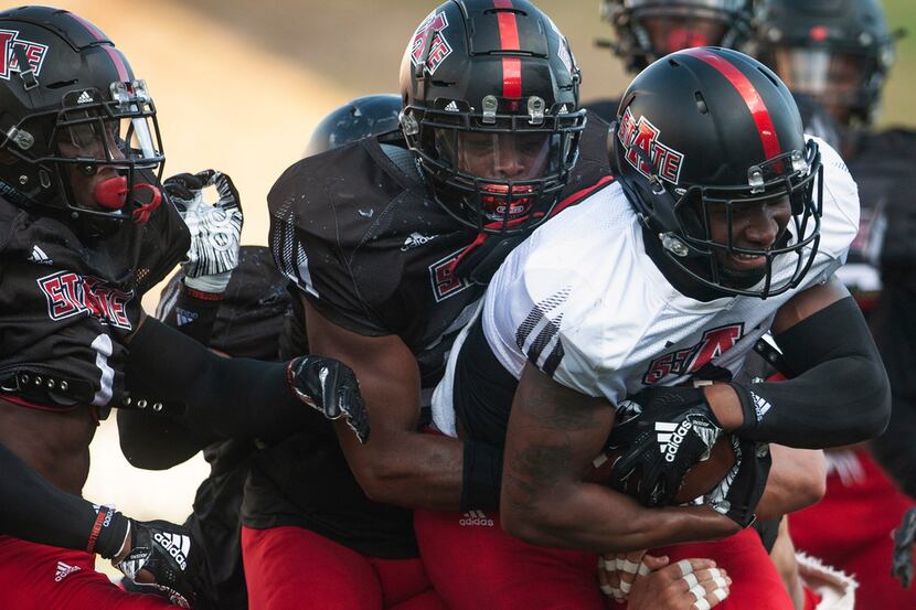 Arkansas State wide receiver Jonathan Adams Jr., front right, is swarmed by defenders after...