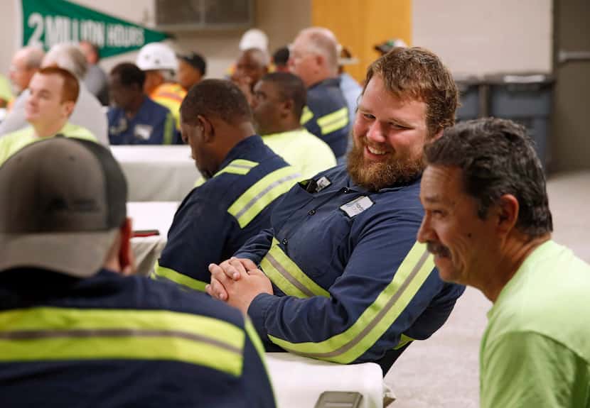 Rusty Hensel (center) shares a laugh with fellow employees Nathen Young (left) and Juan...