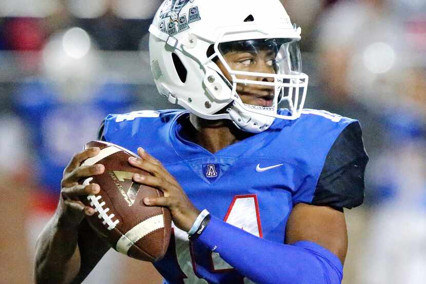 Allen High School quarterback Grant Tisdale (14) drops back to throw during the first half...