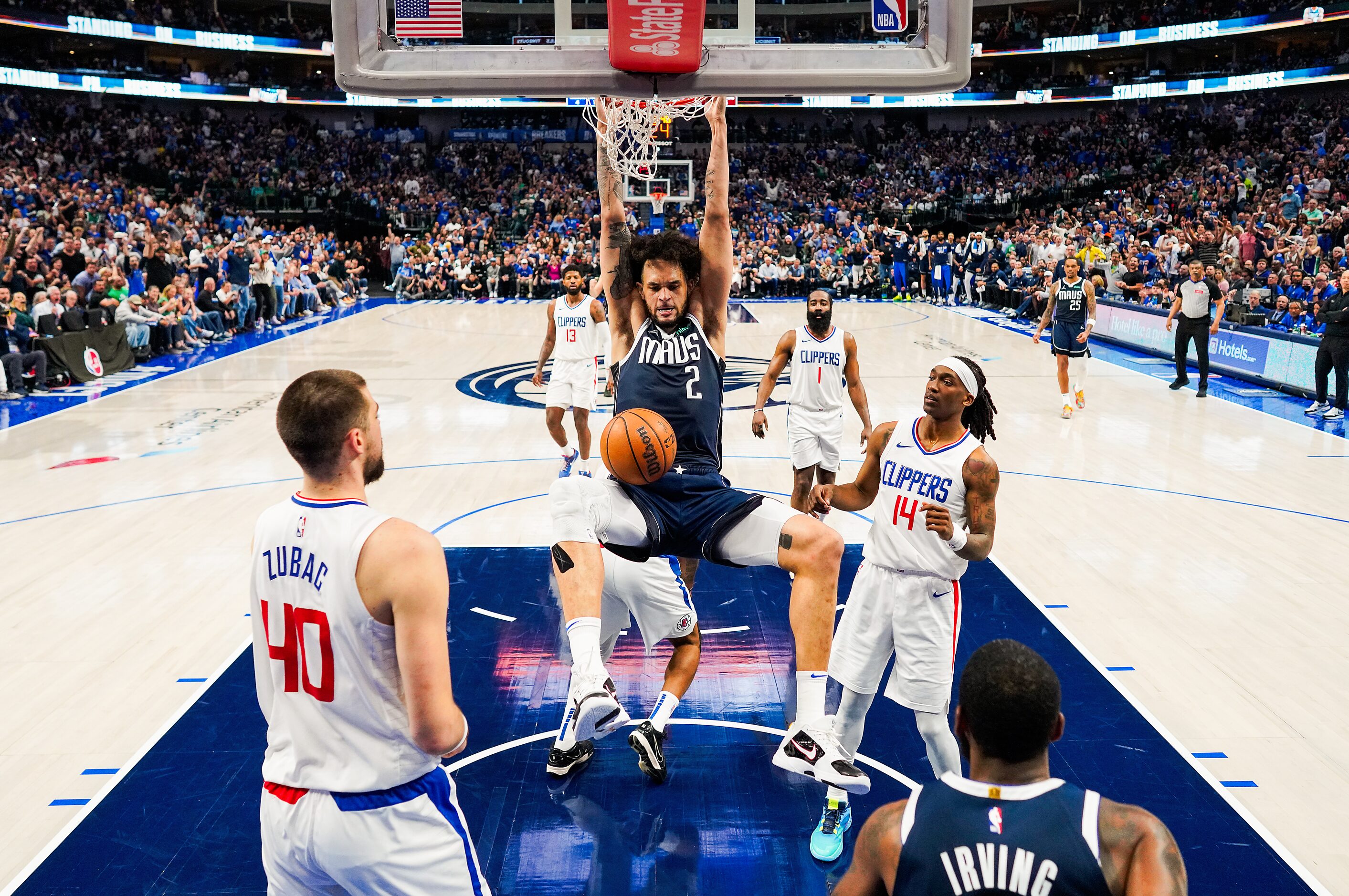 Dallas Mavericks center Dereck Lively II (2) hangs on the rim as he dunks the ball past LA...