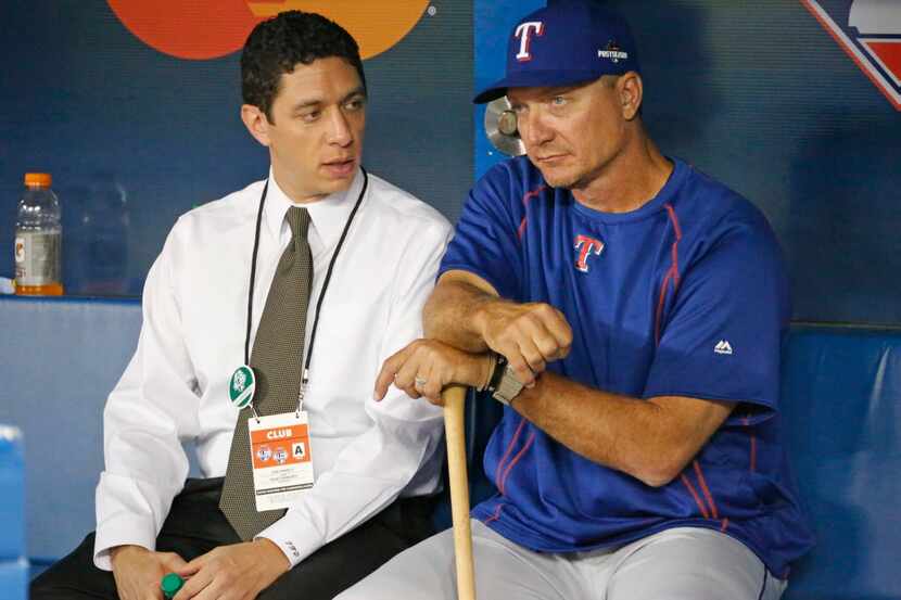 Texas general manager Jon Daniels, left, talks with Texas Rangers manager Jeff Banister (28)...