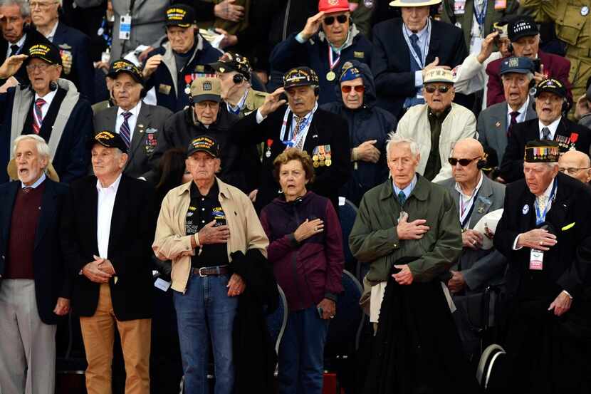 American World War II veterans listen to their national anthem during a French-U.S. ceremony...