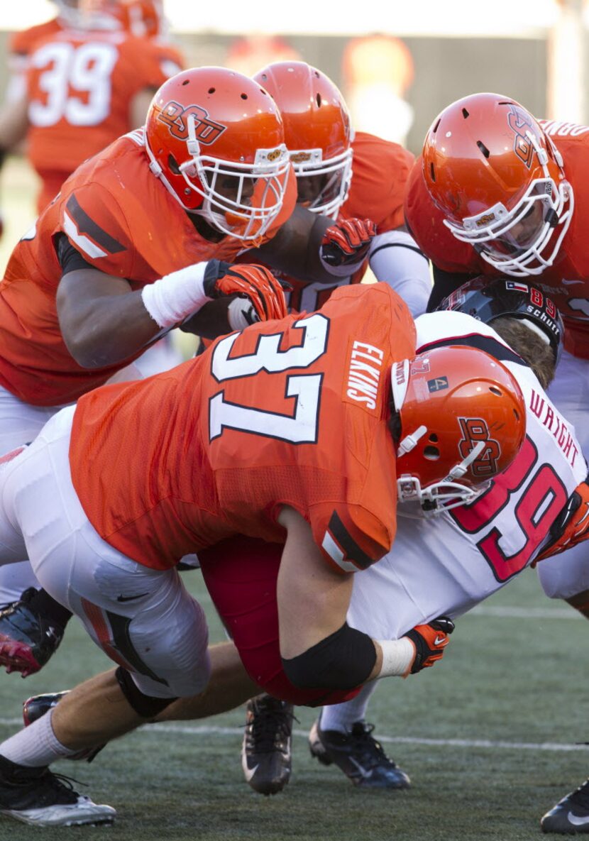 Nov 17, 2012; Stillwater OK, USA; Texas Tech Red Raiders kicker Seth Mannon (39) is tackled...