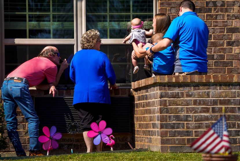 Meagan Myers held her 5-month-old daughter, Callie, up to the window of the baby's...