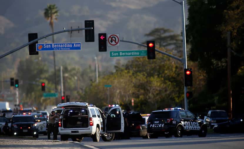 Law enforcement officers with guns drawn on San Bernardino Avenue pursued suspects in a mass...