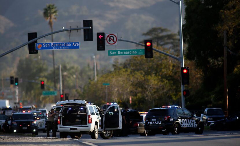 Law enforcement officers with guns drawn on San Bernardino Avenue pursued suspects in a mass...