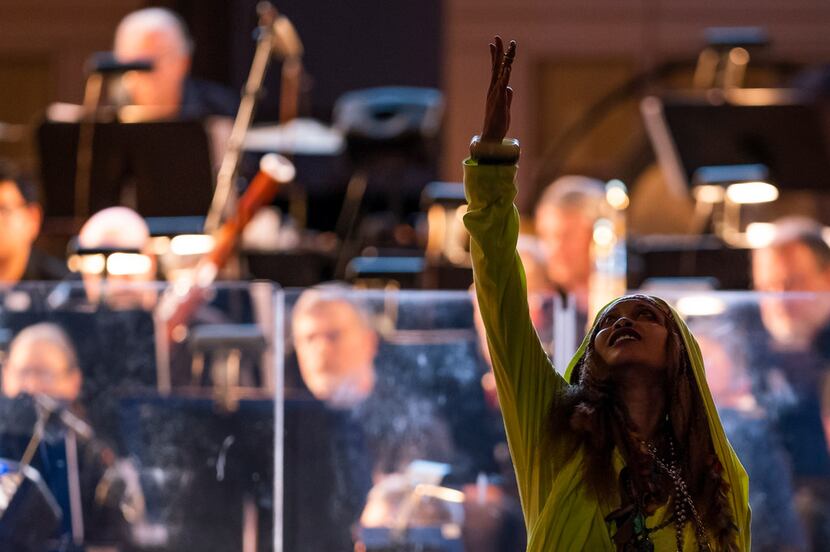 Erykah Badu gestures upward during her show with the Dallas Symphony Orchestra at the...