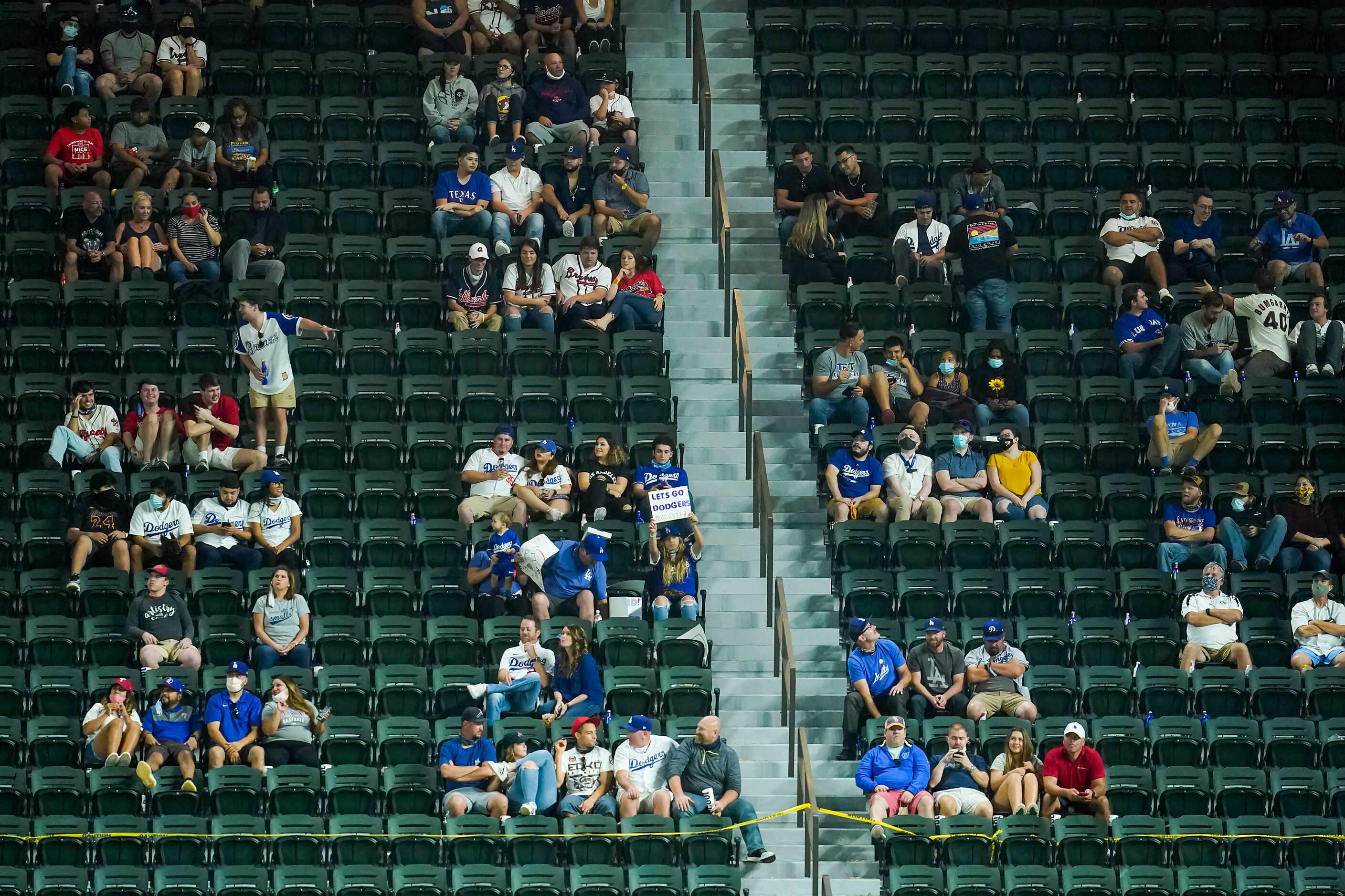 Socially distant fans watch from the right field stands during the ninth inning of the...