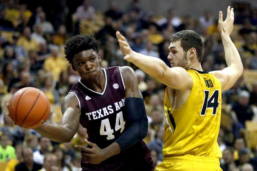 Texas A&M's Robert Williams (44) passes around Missouri's Reed Nikko (14) during the first...