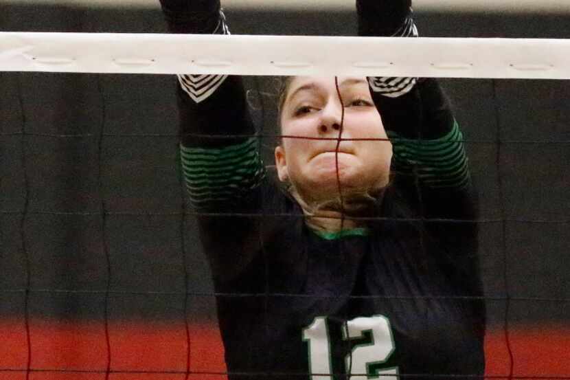 Carroll middle blocker Annabelle Smith (12) gets a piece of the volleyball during the second...
