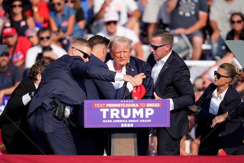 Republican presidential candidate former President Donald Trump is helped off the stage at a...