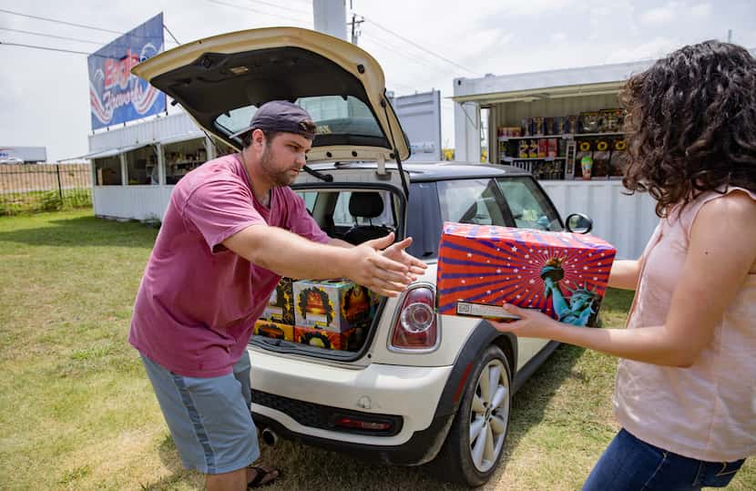 Brock Rodgers of Eagle Fireworks in Midlothian helped Madeline Small load a purchase into...