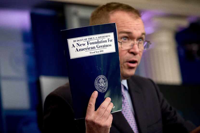 In this May 23, 2017, photo, Budget Director Mick Mulvaney holds up a copy of President...