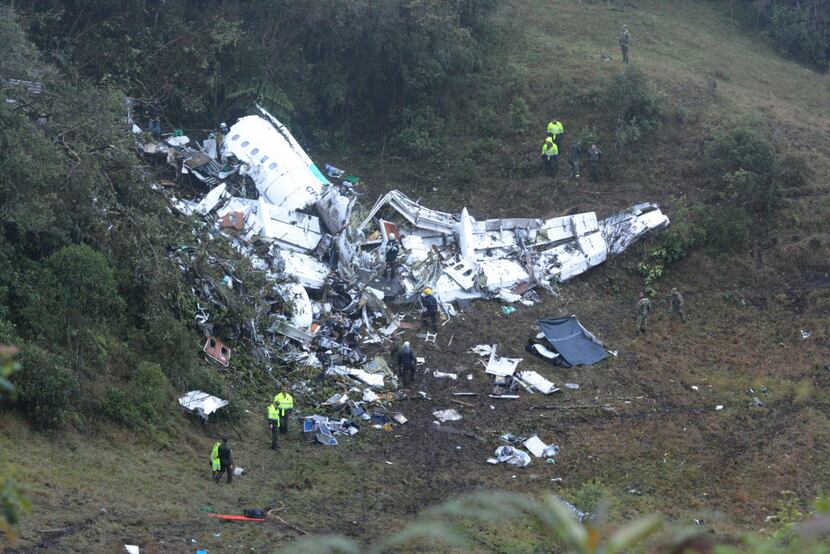 Police officers and rescue workers survey the wreckage of the plane in La Union, Colombia, a...