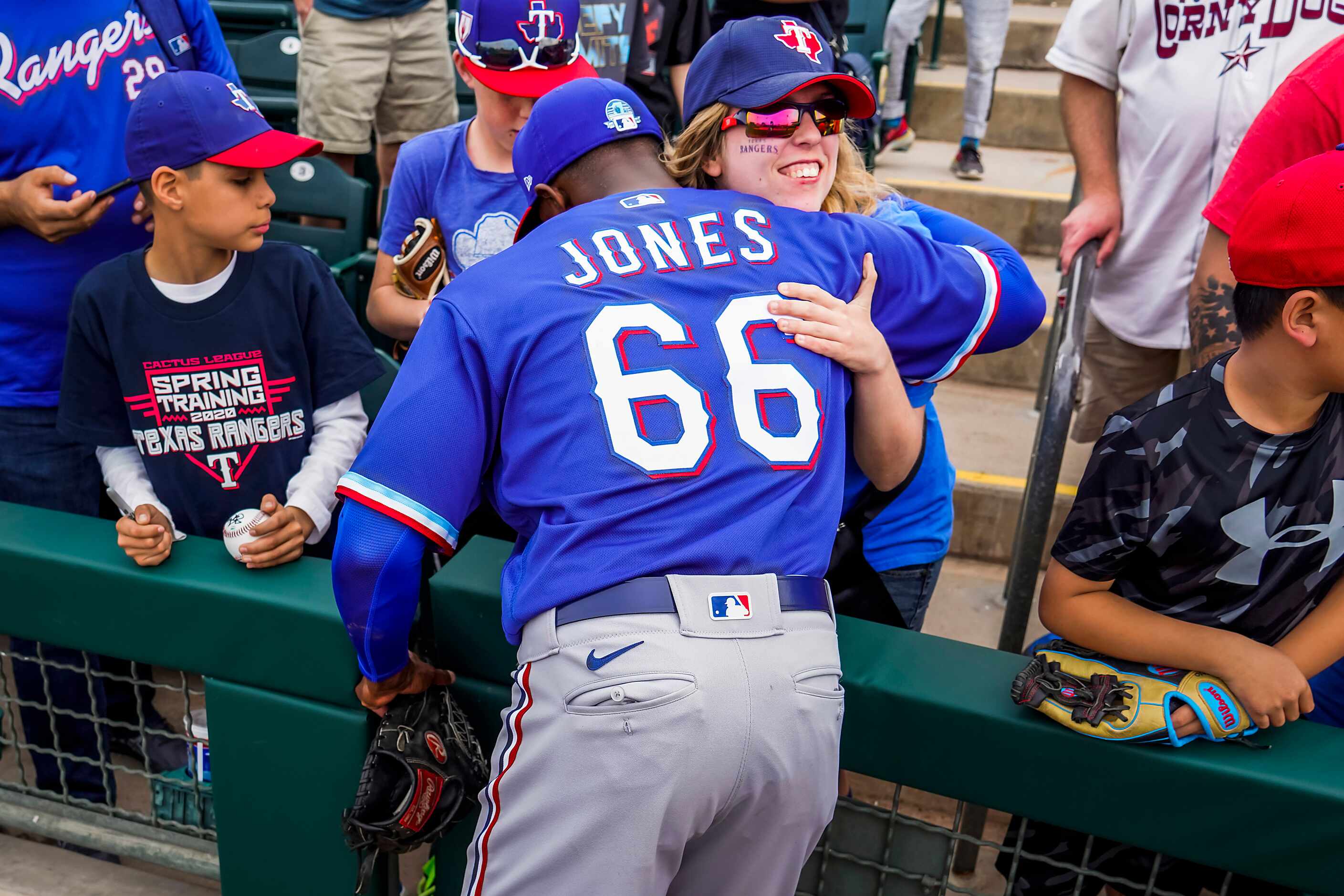 Texas Rangers pitcher James Jones hugs Rangers fan Amber McDonald of Coppell, Texas, after a...
