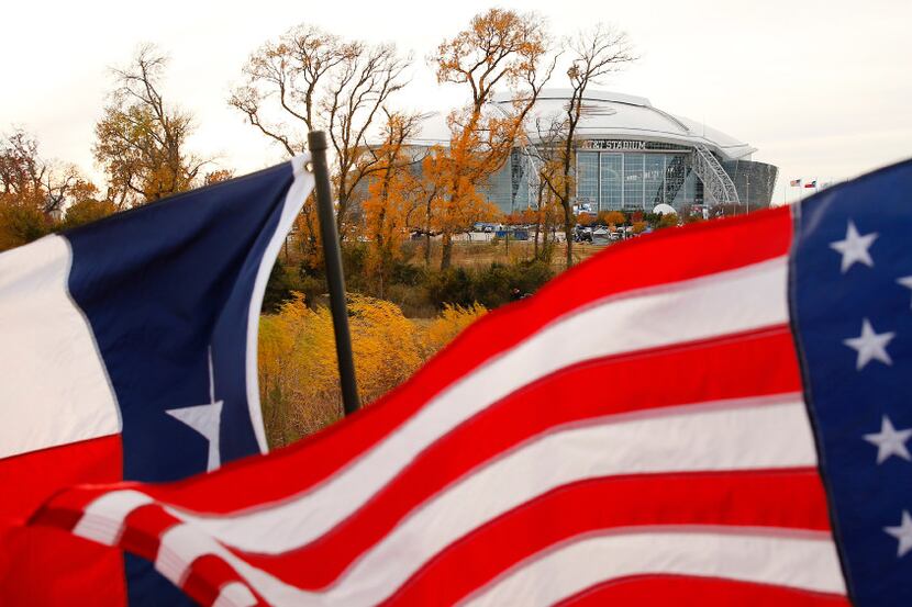 The U.S. and Texas flags fly in the stiff north winds as temperatures hovered around the...