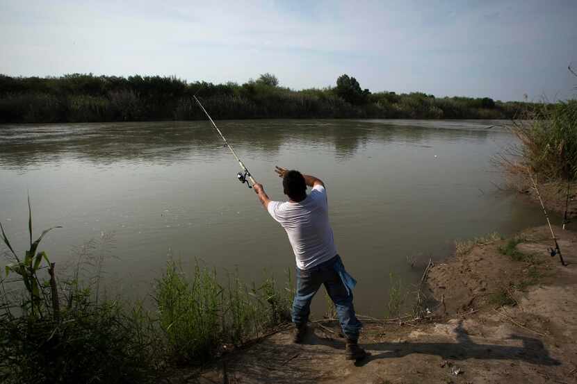 Leo Ayala of Laredo, Texas, casts a line into the Rio Grande River while fishing on...