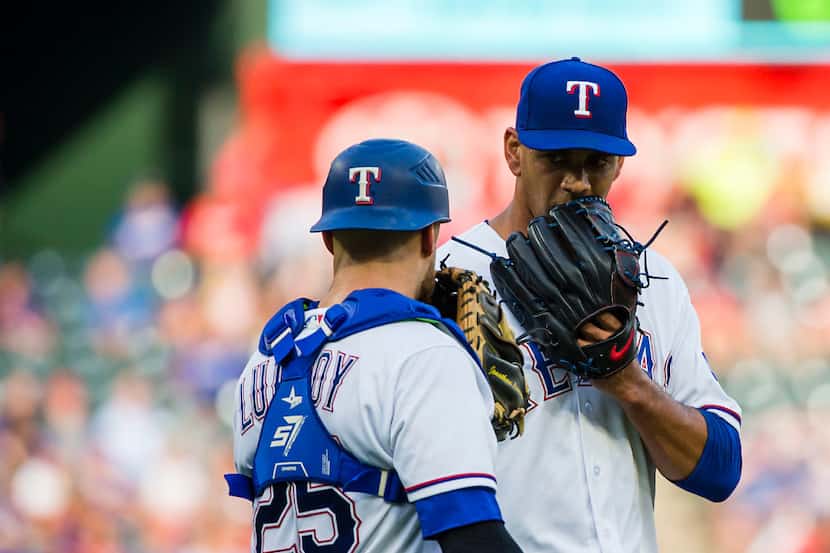 Texas Rangers starting pitcher Tyson Ross gets a visit from catcher Jonathan Lucroy after...