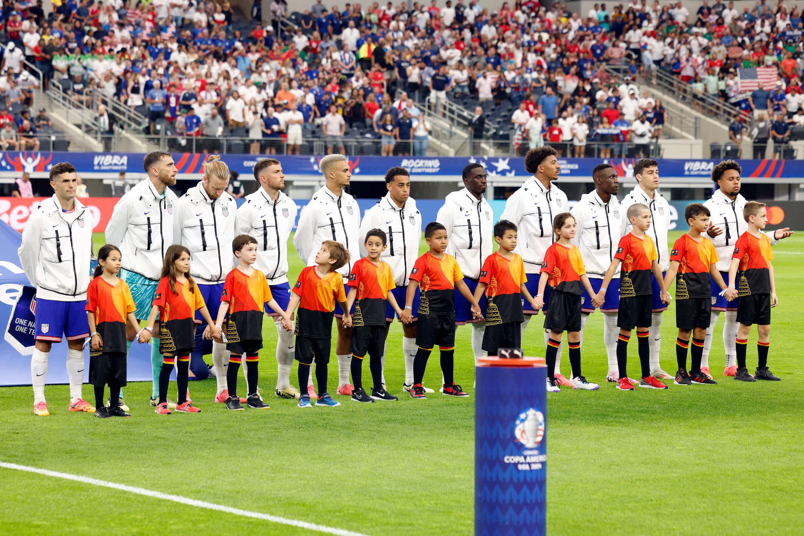 Members of the United States national team stand for the Bolivian national anthem before a...