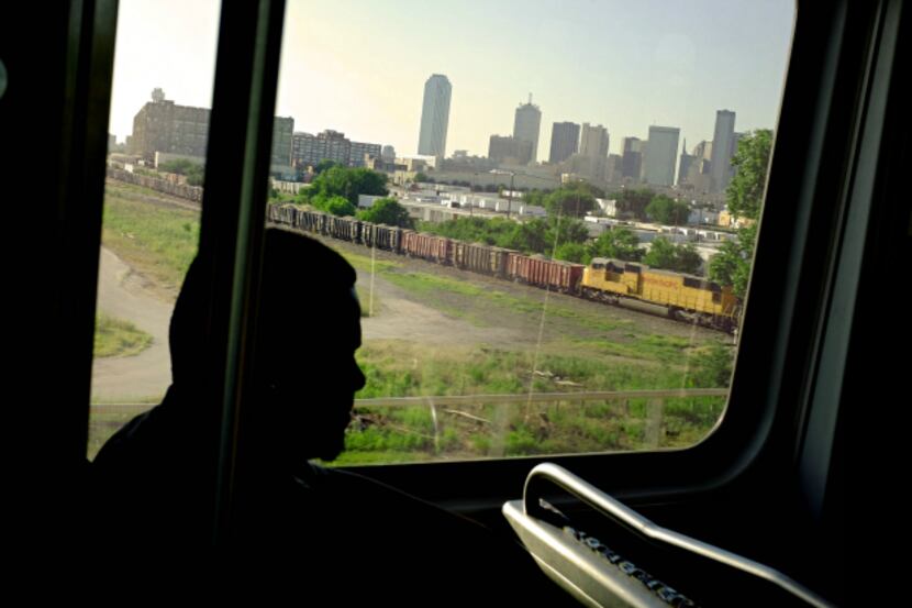 The downtown skyline is seen through the window of a northbound DART Blue Line train.