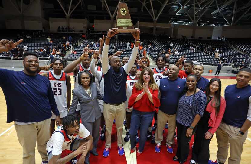 Kimball High head coach Nicke Smith holds the Regional Championship trophy high, as he,...