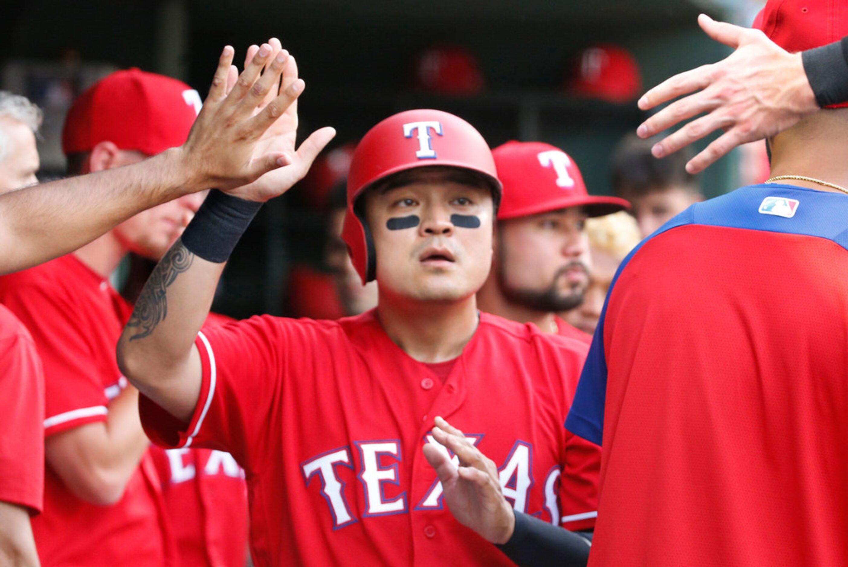 Texas Rangers right fielder Shin-Soo Choo (17) is congratulated by teammates in the dugout...