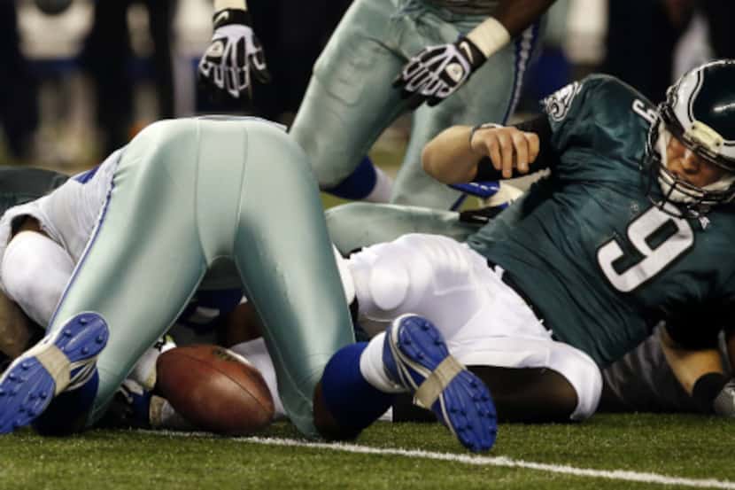 Dallas Cowboys defensive end DeMarcus Ware, over ball, falls on a fumble by Philadelphia...