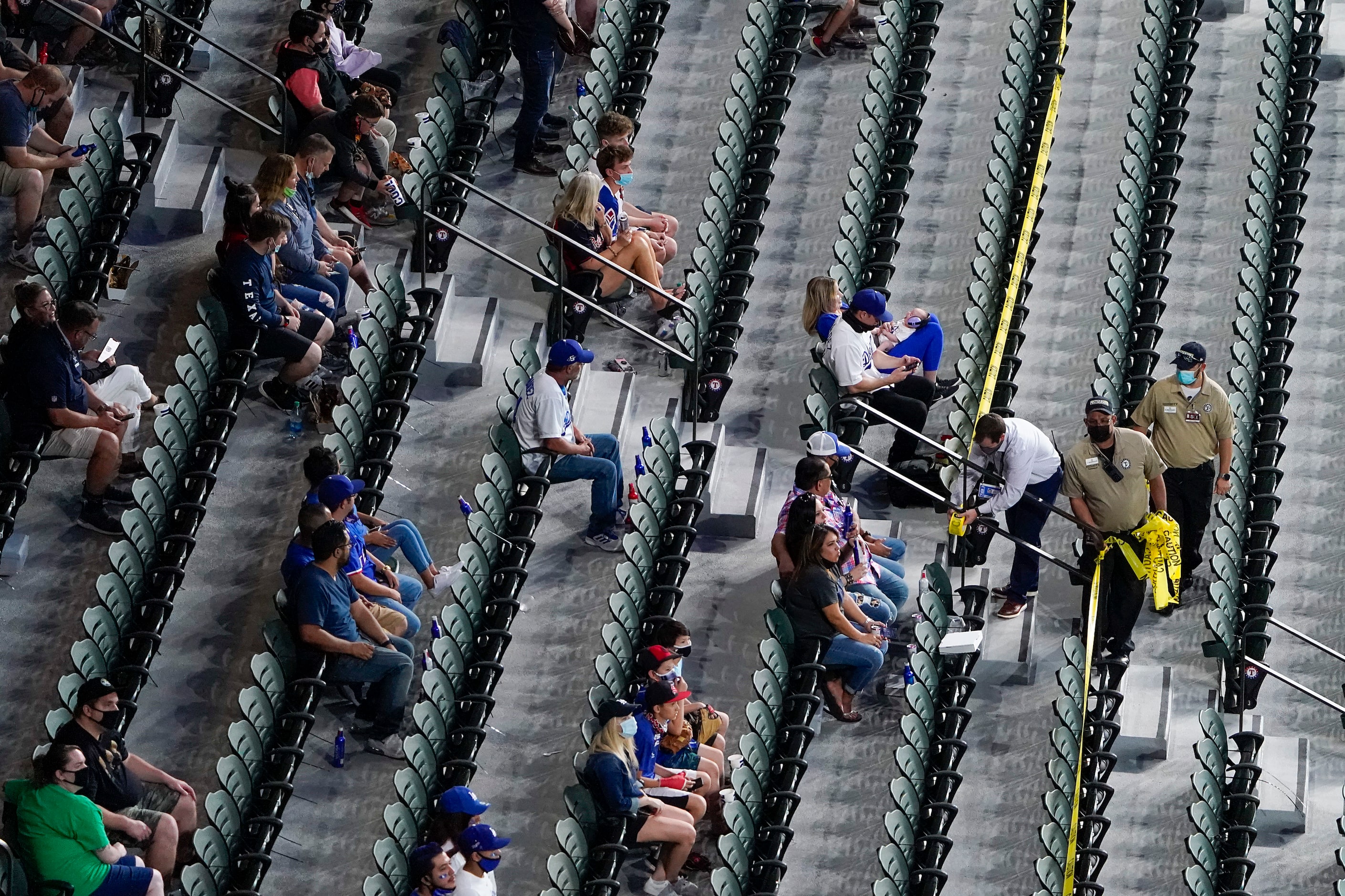 Stadium workers use tapes to mark out-of-bounds seating in right field before Game 1 of a...