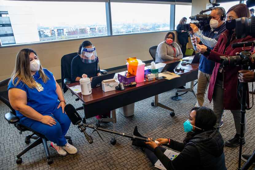 Nurse manager Dolores Diaz speaks with media members prior to receiving a dose of the Pfizer...