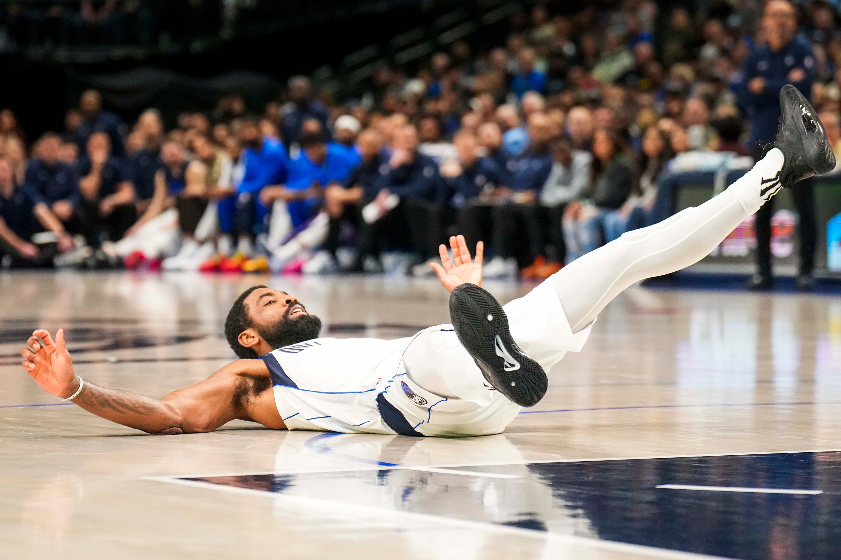 Dallas Mavericks guard Kyrie Irving celebrates as he hits the floor after making a shot...