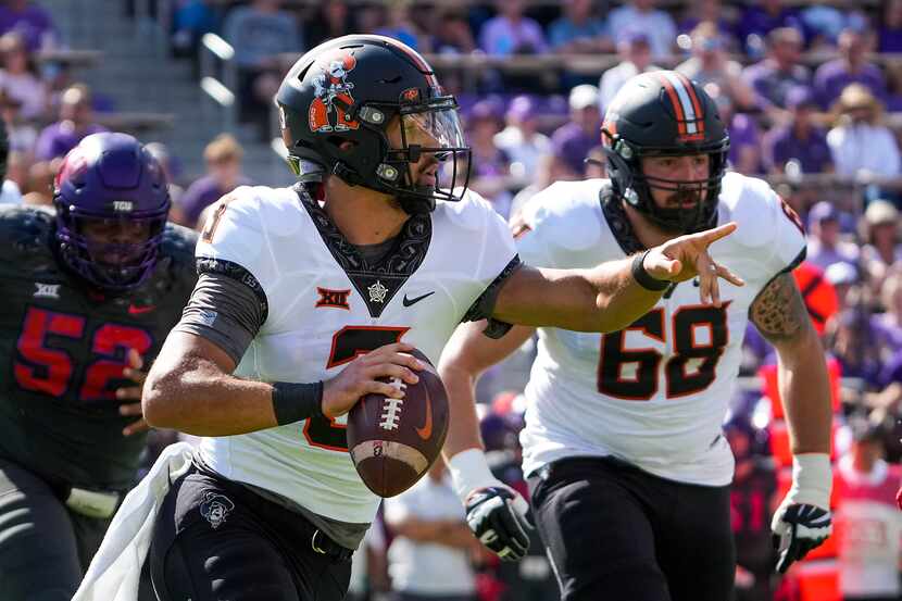 Oklahoma State quarterback Spencer Sanders (3) scrambles away from the TCU pass rush during...