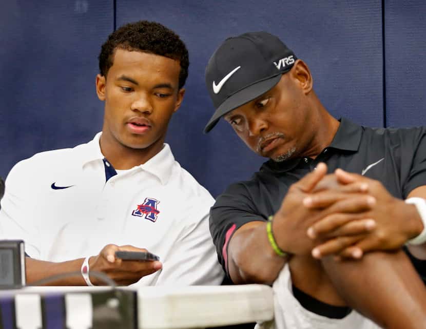 Allen High School quarterback Kyler Murray (left) shows his phone to his father Kevin who...