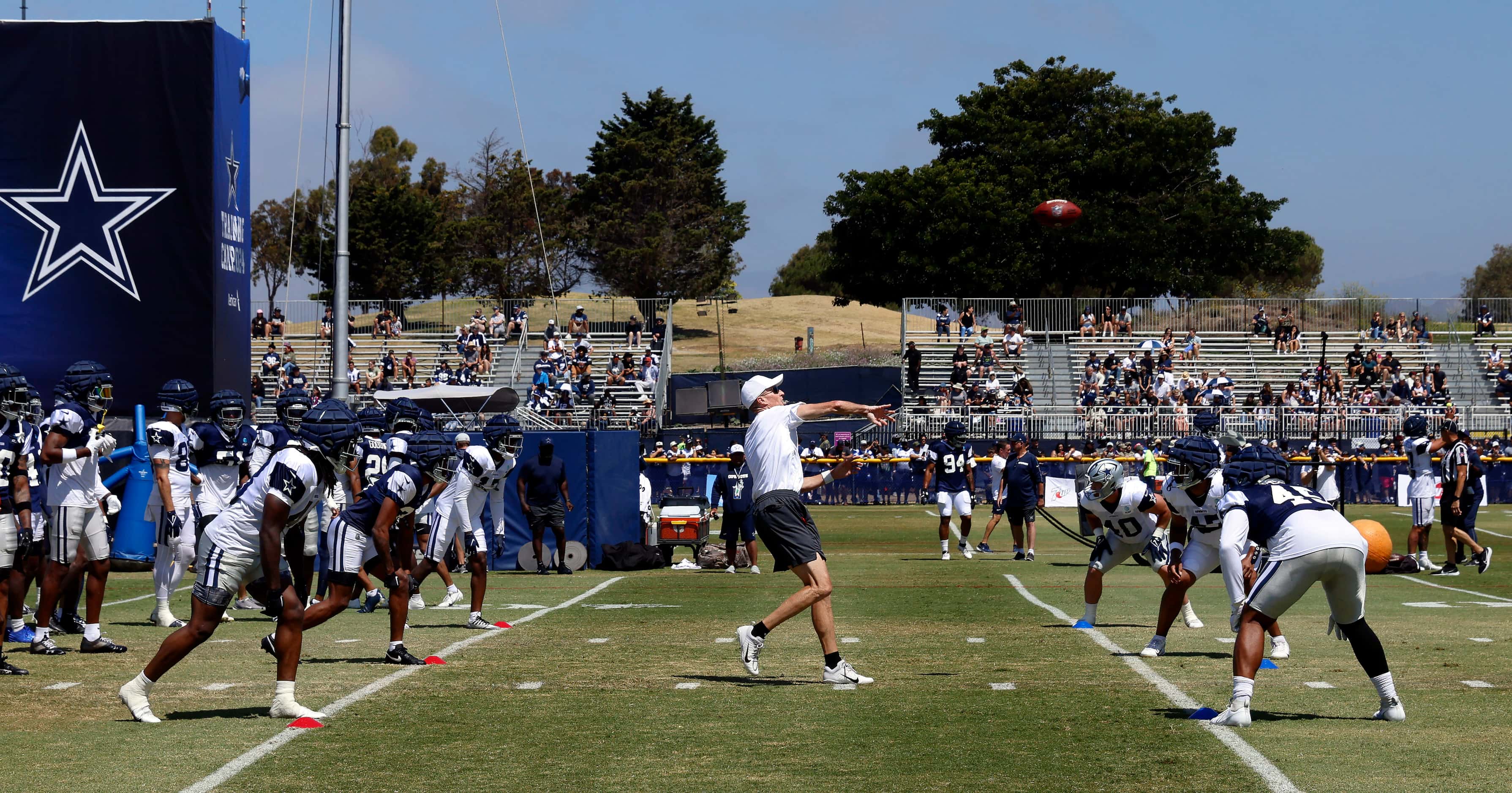 Dallas Cowboys special teams coach John Fassel throws the ball to start the new kickoff...