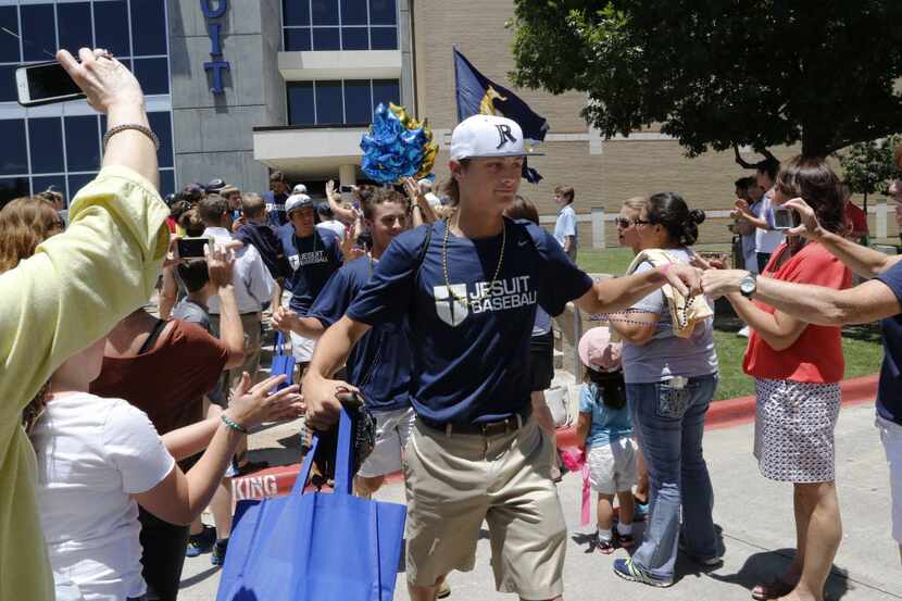 Jesuit’s baseball player Cameron Dobbs gets high fives from family and friends as he and his...