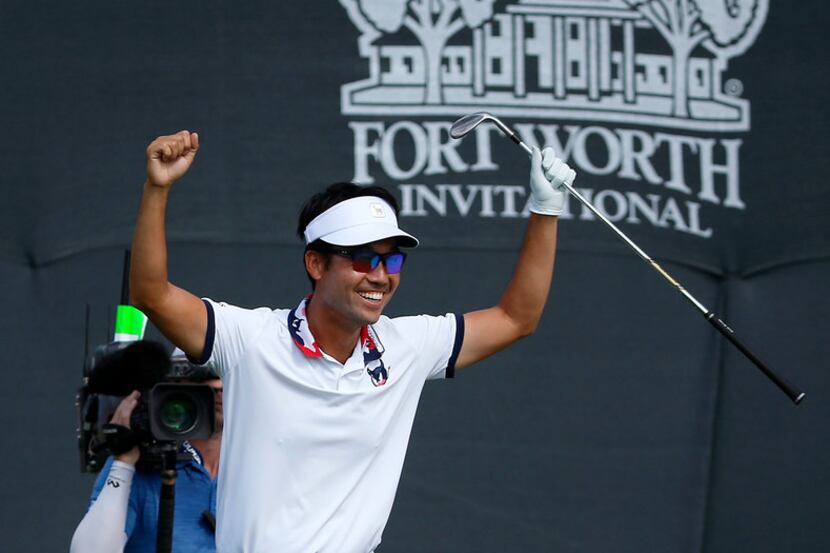 Kevin Na raises his hands in celebration after he chips in for a birdie on the 9th green...