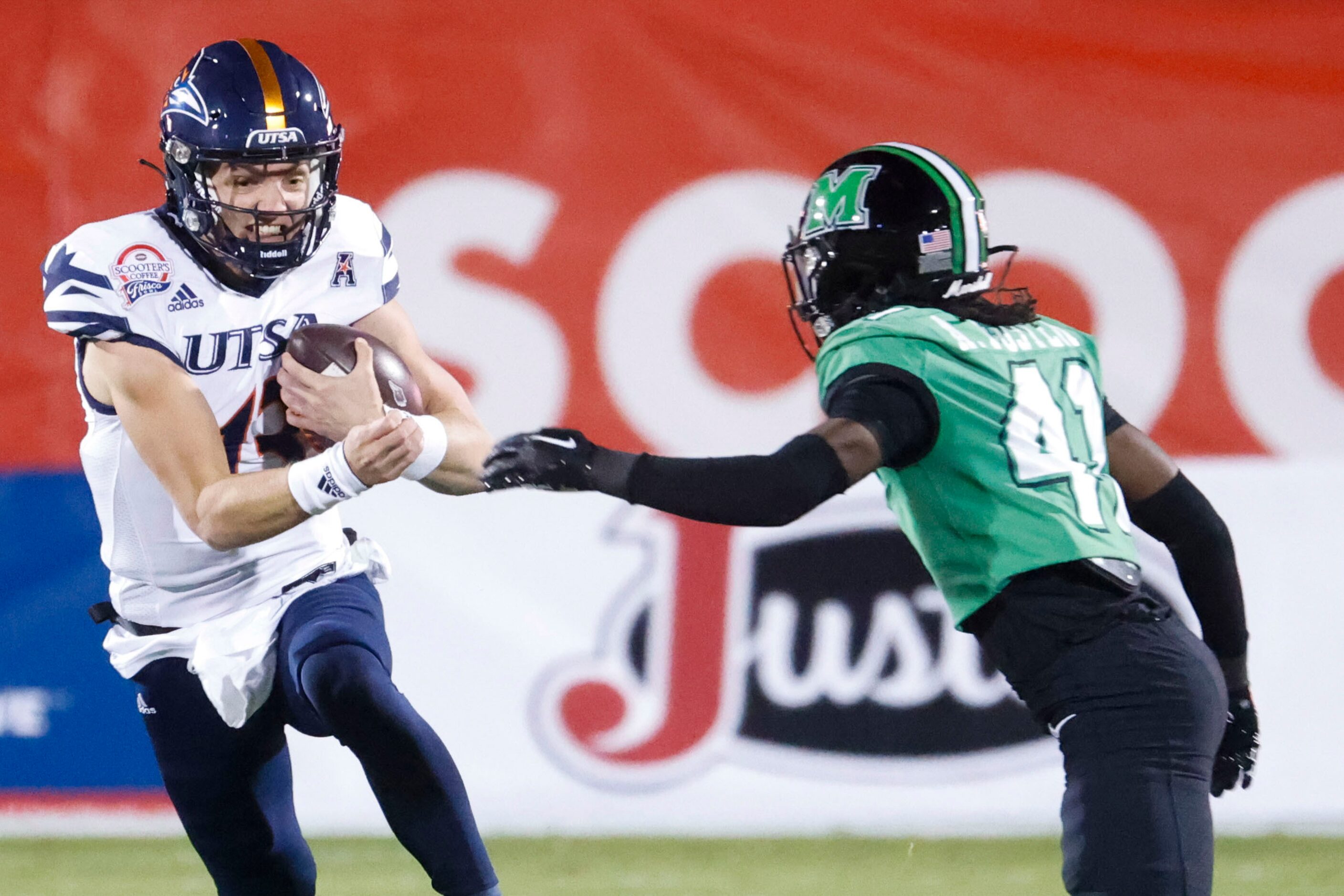 UTSA quarterback Owen McCown (left) attempts to run past before getting tackled by Marshall...