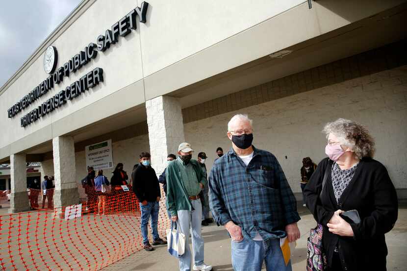 Wearing masks outside, Robert and Connie Clark of Garland wait in line to have their...