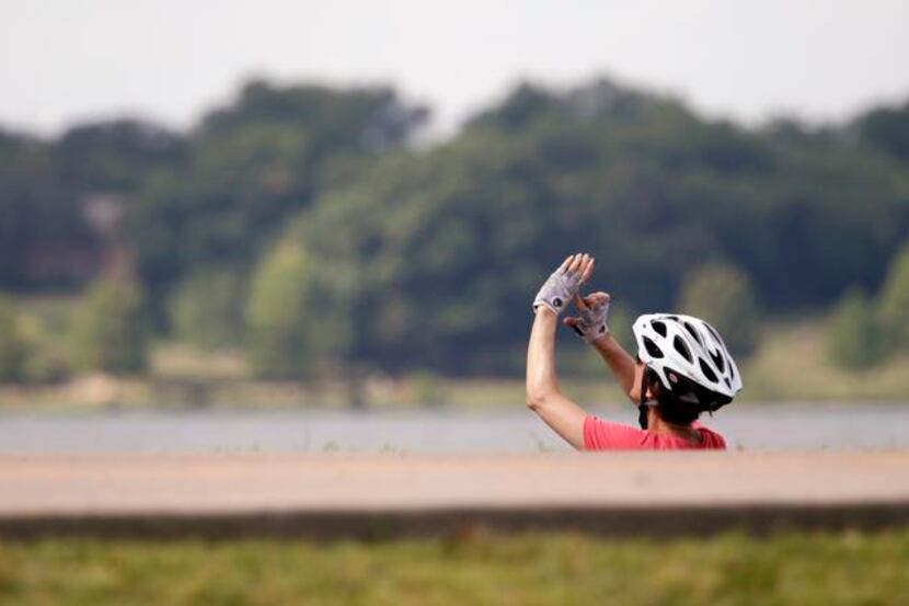 
White Rock Lake is where the bike riders are, including Debbie McKee, who paused to...