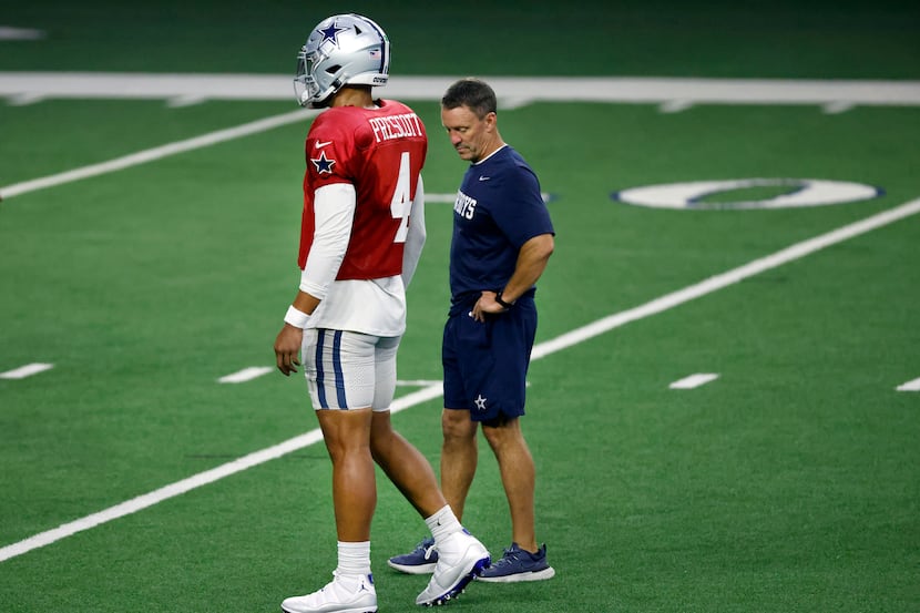 Dallas Cowboys associate athletic trainer Britt Brown observes quarterback Dak Prescott (4)...