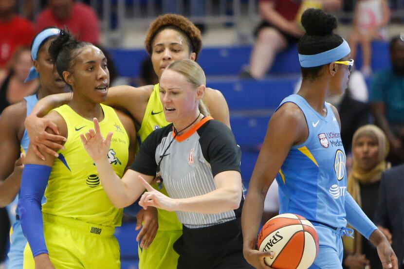 A game official quickly steps between Dallas Wings forward Kayla Thornton (6), left, as...