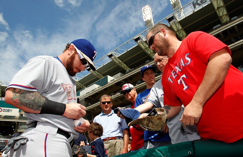 Texas Rangers' Josh Hamilton signs an autograph for a fan prior to the Rangers baseball game...